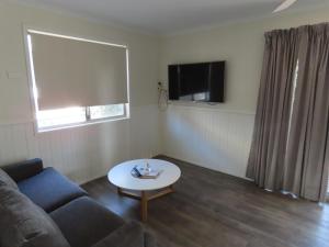 a living room with a couch and a table at Albury Gardens Tourist Park in Lavington