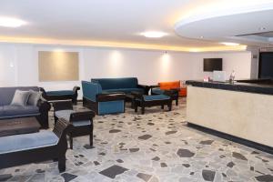 a waiting room with couches and chairs and a bar at Hotel Inambu Villavicencio in Villavicencio