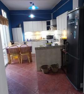una cucina con frigorifero nero e tavolo con sedie di CasaCocco a Olivos