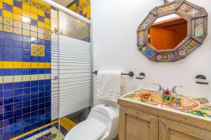 a bathroom with a toilet and a sink and a mirror at Hostería Casa Miranda Marquez in León