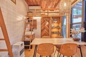 uma pequena casa com uma sala de jantar com mesa e cadeiras em サウナ・ジャグジー・完全貸し切りという贅沢　大人の秘密基地　Tiny Cabin TATEGU#02 em Miyota
