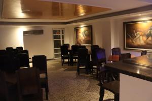 比亞維森西奧的住宿－Hotel Inambu，用餐室设有椅子和墙上的绘画作品