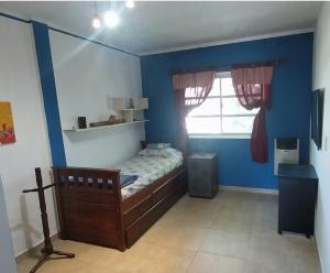 - une chambre avec un lit et un mur bleu dans l'établissement CasaCocco, à Olivos