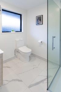 bagno bianco con servizi igienici e finestra di 1 bedroom 1 bath, Executive escape, Northlands Mall a Christchurch