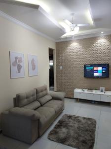 a living room with a couch and a tv on a wall at Casa da Montanha in Miguel Pereira