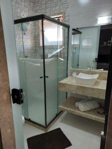 W łazience znajduje się szklana kabina prysznicowa i umywalka. w obiekcie Casa da Montanha w mieście Miguel Pereira