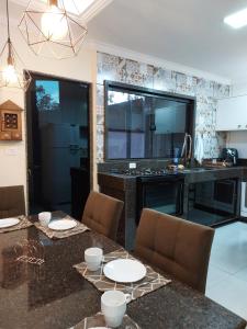 a kitchen with a table and chairs and a counter at Casa da Montanha in Miguel Pereira