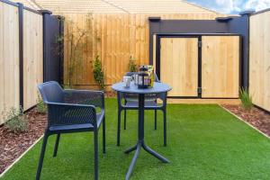un patio con tavolo e 2 sedie in erba di 1 bedroom 1 bath, Executive escape, Northlands Mall a Christchurch