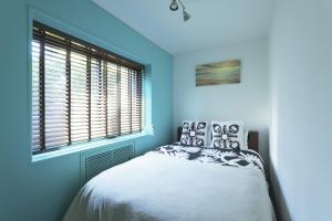 a blue bedroom with a bed and a window at 葉山THE TERRACE HOUSE in Hayama
