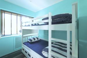 een slaapkamer met 2 stapelbedden in een blauwe kamer bij 葉山THE TERRACE HOUSE in Hayama