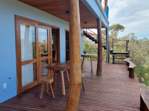 a wooden deck with a table and stool on a house at Casa Prosperidade in Alto Paraíso de Goiás