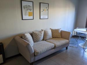 a couch in a living room with pictures on the wall at CasaUno in San Antonio de Areco