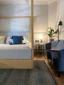 een slaapkamer met een groot bed en een stoel bij Aposento Boutique Hotel in Mexico-Stad
