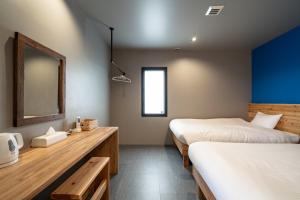 Cette chambre comprend 2 lits et un miroir. dans l'établissement こてーじDo, à Nagura