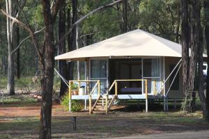 a gazebo with a porch in the woods at Two Fat Blokes African Safari Glamping in Pokolbin