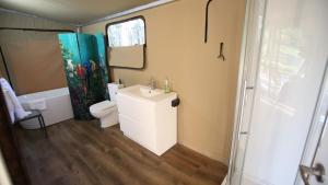 małą łazienkę z toaletą i umywalką w obiekcie Two Fat Blokes African Safari Glamping w mieście Pokolbin