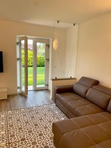 a living room with a couch and a sliding glass door at Guest Martilla Luxury & Garden in Garda