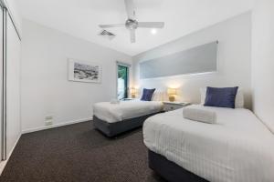 1 dormitorio con 2 camas y ventana en Holiday home Alex Headland, en Alexandra Headland