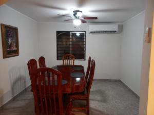 a dining room with a table and chairs and a ceiling fan at Casa Blanca in Reynosa