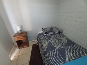 a small bedroom with a bed and a night stand at Alojamiento jv QUILLOTA AMOBLADA in Quillota