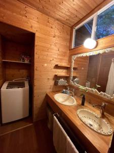 Baño con 2 lavabos en una cabaña de madera en 4月リニューアルOpen! 全室エアコン完備! Deerview Lodge 山中湖, en Yamanakako