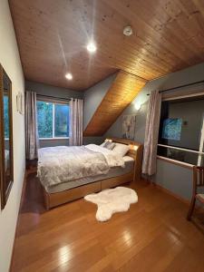 1 dormitorio con 1 cama con techo de madera en 4月リニューアルOpen! 全室エアコン完備! Deerview Lodge 山中湖, en Yamanakako