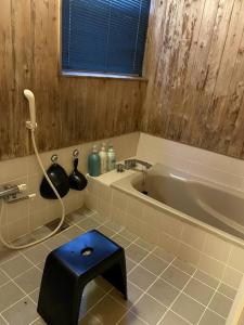 baño con bañera y taburete azul en 4月リニューアルOpen! 全室エアコン完備! Deerview Lodge 山中湖, en Yamanakako
