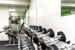 a row of dumbbells in a gym at Luxury Stay with Sauna Gym and Pool in Leicester in Leicester