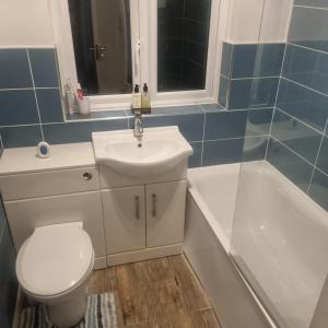 a bathroom with a toilet and a sink and a tub at double room in Thornton Heath