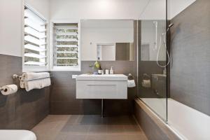 a bathroom with a white sink and a shower at Aaman & Cinta Luxury Villas in Byron Bay