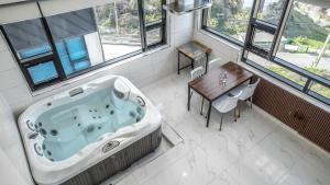 a bath tub in a room with a table and a dining room at Jini Spa Pension B in Geoje 