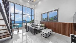 a living room with a couch and some windows at Jini Spa Pension B in Geoje 