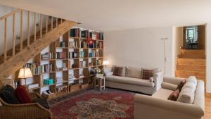uma sala de estar com uma estante de livros com livros em Ches'Ota - Verde - La Punt em La Punt-Chamues-ch