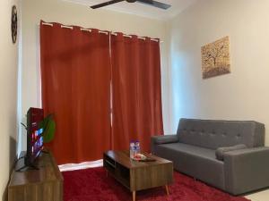 a living room with a couch and a red curtain at SYG 8 Aura Suite Putrajaya Studio Unit in Putrajaya