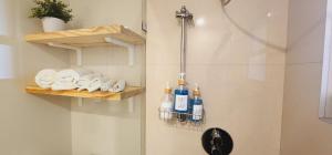 een badkamer met een douche, flessen en handdoeken bij Private Aparment Studio in the hard of Miami unit # 6 in Opa-locka
