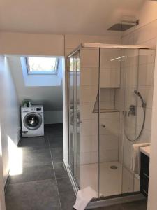 a bathroom with a shower and a washing machine at Ferienwohnung in Buchenberg mit Garten und Terrasse in Buchenberg