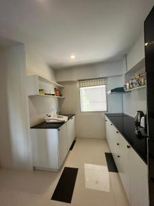 una pequeña cocina con armarios blancos y una ventana en Replay Residences Samui, en Bangrak Beach