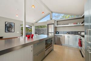 cocina con electrodomésticos de acero inoxidable y ventana grande en Five Mile Bliss - Lake Taupo Holiday Home, en Waitahanui