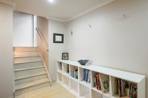 a staircase in a room with bookshelves at Five Mile Bliss - Lake Taupo Holiday Home in Waitahanui