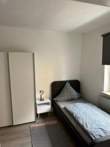 a small bedroom with a bed and a mirror at Quins in Aalen