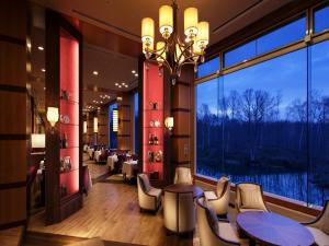 a restaurant with tables and chairs and a large window at Hakodate-Onuma Prince Hotel in Nanae