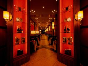 a corridor of a restaurant with red walls and tables at Hakodate-Onuma Prince Hotel in Nanae