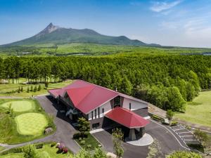 an aerial view of a building with a mountain in the background at Hakodate-Onuma Prince Hotel in Nanae