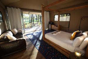 a bedroom with a large bed and a couch at Two Fat Blokes Moroccan Glamping in Pokolbin