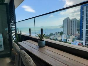 a wooden table with a potted plant on a balcony at Q House- FLC Sea Tower in Quy Nhon