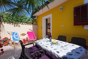 - une table à manger et des chaises dans une pièce dotée d'un mur jaune dans l'établissement Holiday Homes in Porec - Istrien 42537, à Poreč