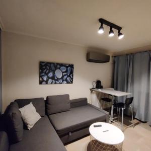 ein Wohnzimmer mit Sofa und Tisch in der Unterkunft Theo's loft in Athen