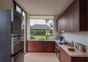 cocina con nevera de acero inoxidable y ventana en Ocean View 3 Bedrooms Brand New Stylish Villa With Private Pool, Gazebo, & Garden, Bali, en Ketewel