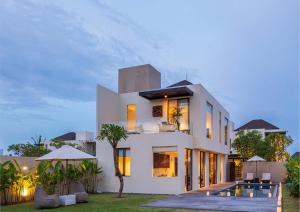 une maison blanche avec une piscine en face de celle-ci dans l'établissement Ocean View 3 Bedrooms Brand New Stylish Villa With Private Pool, Gazebo, & Garden, Bali, à Ketewel