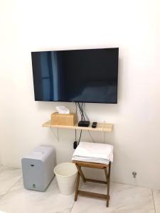 une télévision à écran plat suspendue sur un mur avec une table. dans l'établissement 日日見宅 Matsuya, à Huwei